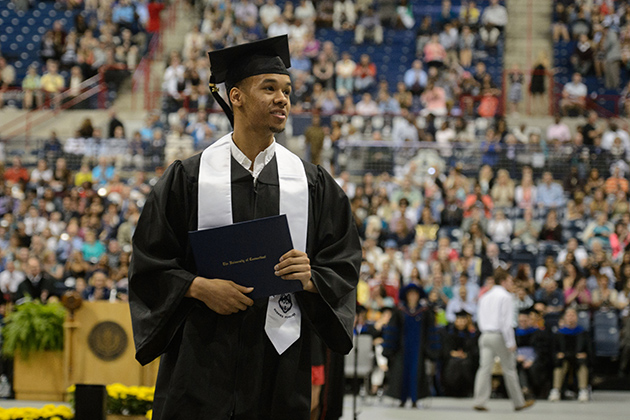 Men's basketball standout Shabazz Napier '14 (CLAS) walks across the floor at Gampel Pavilion after receiving his diploma, during the College of Liberal Arts and Sciences commencement ceremony on May 11. (Peter Morenus/UConn Photo)