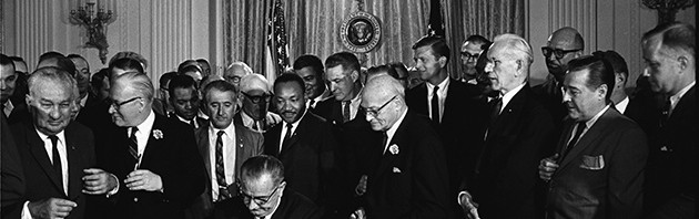 President Lyndon Johnson signs the Civil Rights Act at the White House in 1964. (Photo from the LBJ Presidential Library)