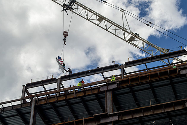The final steel beam, signed by Gov. Dannel P. Malloy and others, is hoisted into place on the UConn Health hospital tower, part of the Bioscience Connecticut initiative at the Farmington campus. (Tina Encarnacion/UConn Health Photo)