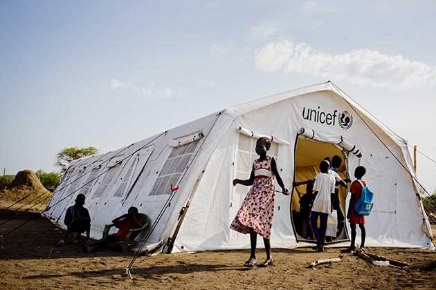 Children displaced by fighting in South Sudan stand outside a tented school run by UNICEF. (UNICEF Photo)