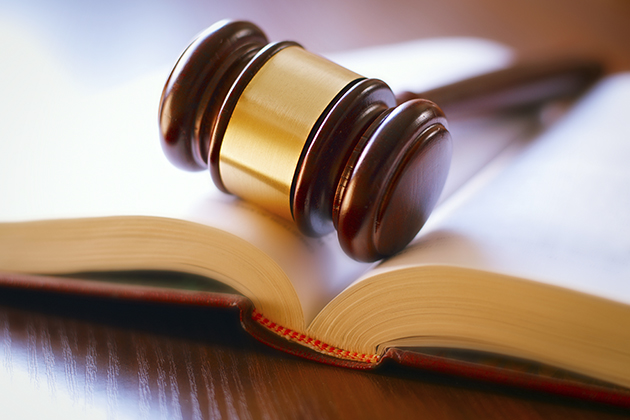 Gavel and open book on a wooden table in the courtroom. (iStock Photo)