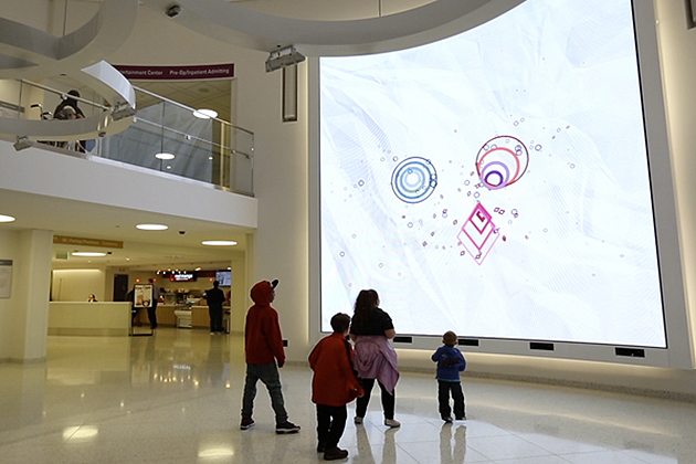 An interactive digital wall in the lobby of Boston Children's Hospital was designed by researchers at the University of Connecticut.