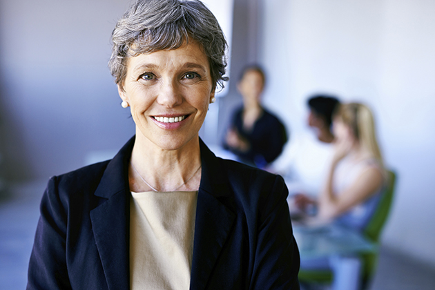 A female business woman with colleagues in the background. (iStock Photo)