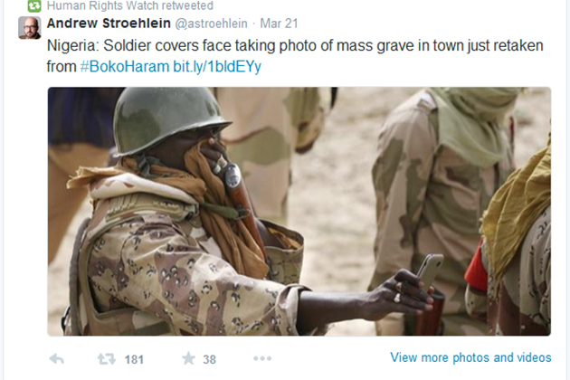 A screen shot from the Human Rights Watch Twitter feed shows a soldier taking photos of a mass grave site in Nigeria.