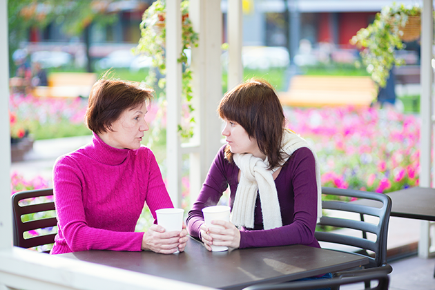 Mother and adult daughter chat over a cup of coffee. (iStock Photo)