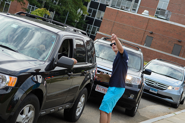 Derek Tata '16 (ENG), a resident assistant, directs cars at the North Campus Residence Halls on Aug. 23, 2013. (Ariel Dowski '14 (CLAS)/UConn Photo)