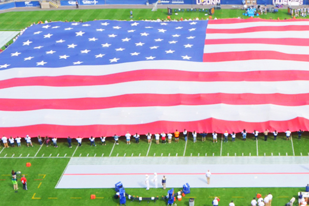 Volunteers unfurl a giant flag before the start of the UConn vs Navy football game on Sept. 26, 2015. (Ryan Glista '16 (CLAS)/UConn Photo)