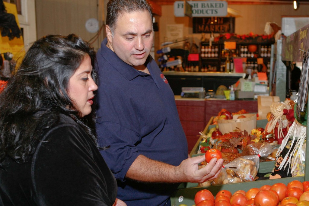 An overweight couple buying tomatoes in a grocery store. (UConn Rudd Center for Food Policy & Obesity Photo)