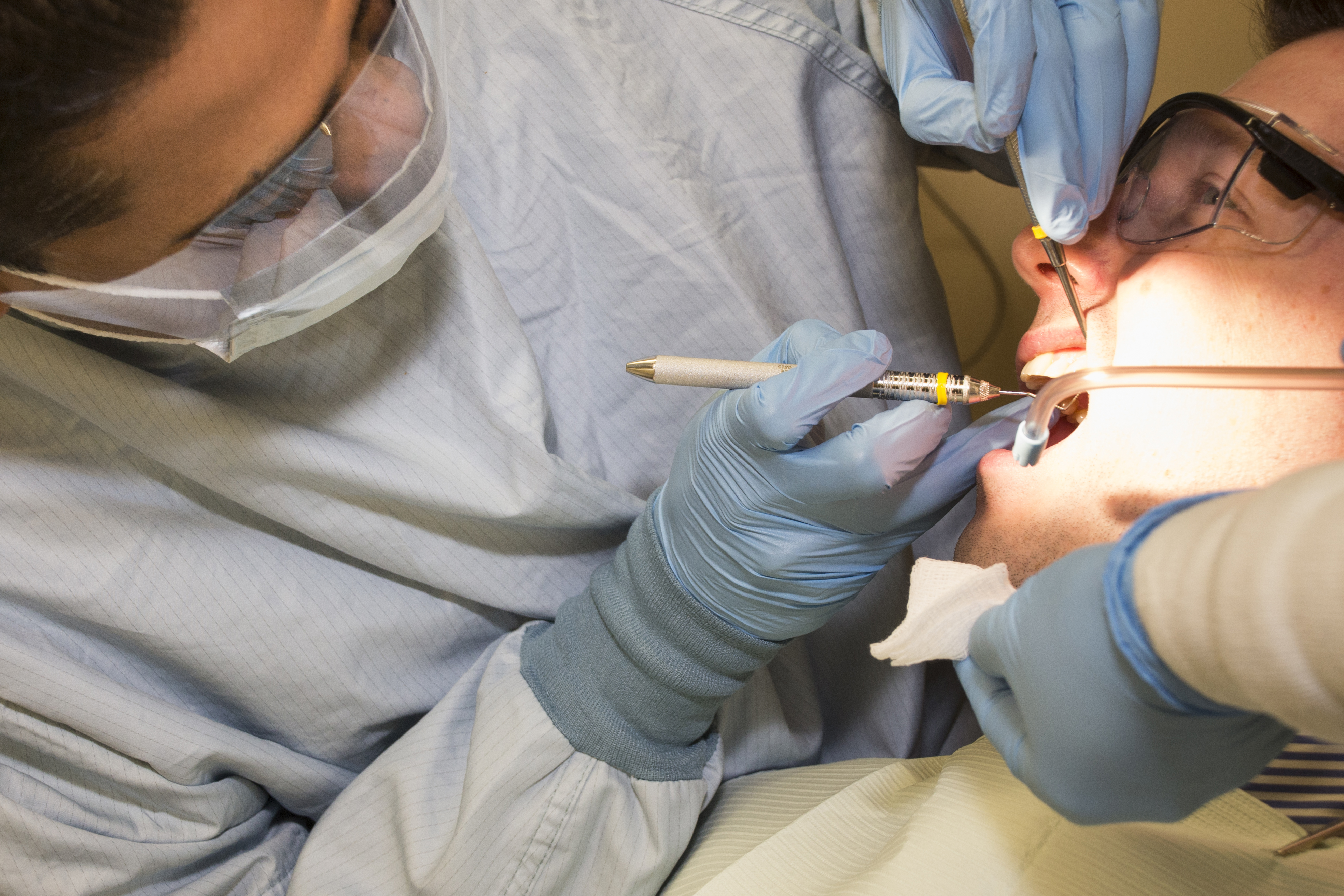 Dr. Avinash Bidra conducts a dental exam. (Janine Gelineau/UConn Health Photo)