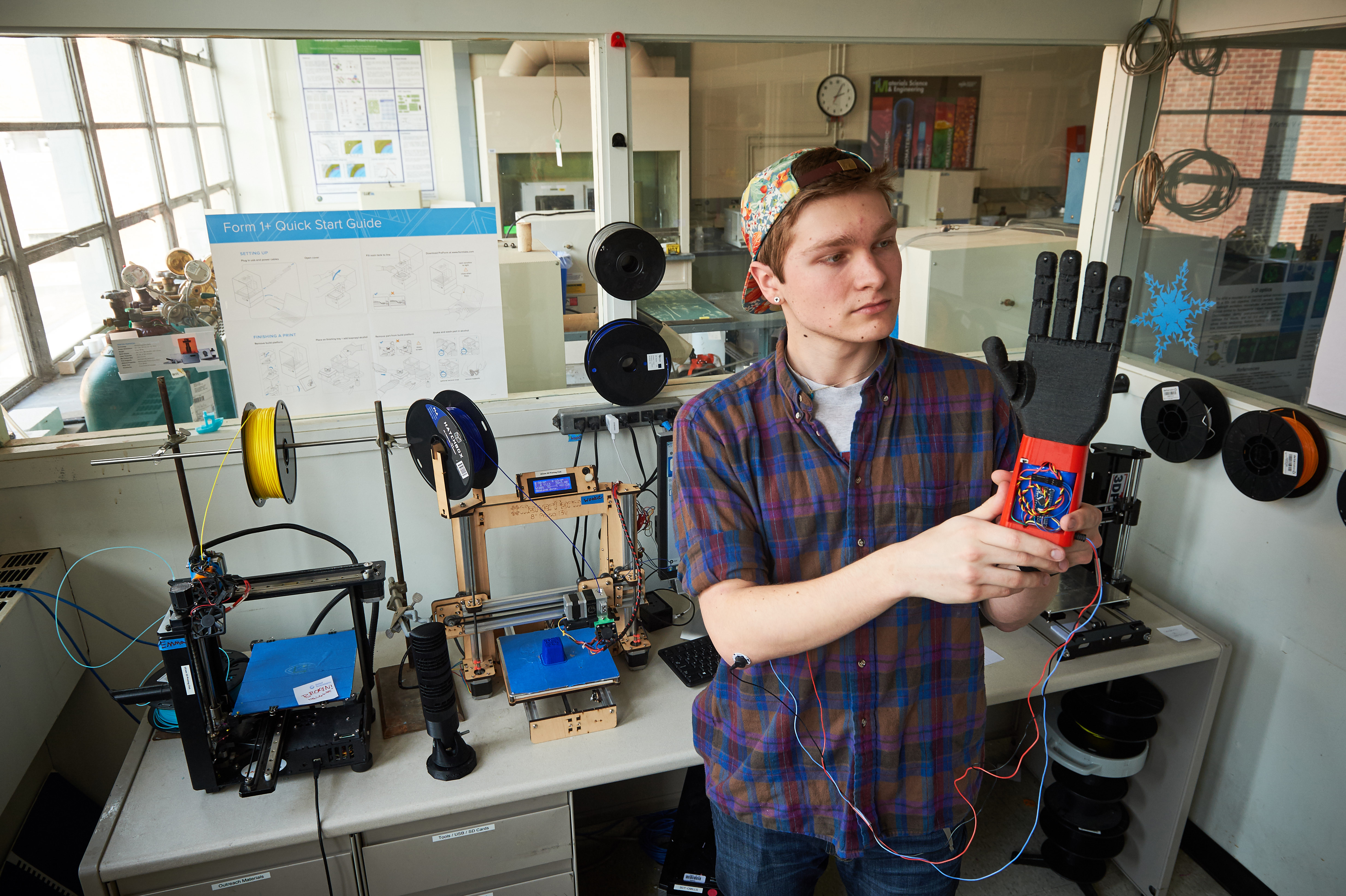 Stephen Hawes '17 (ENG) holds a 3-D printed prosthetic hand on Feb. 1, 2016. (Peter Morenus/UConn Photo)