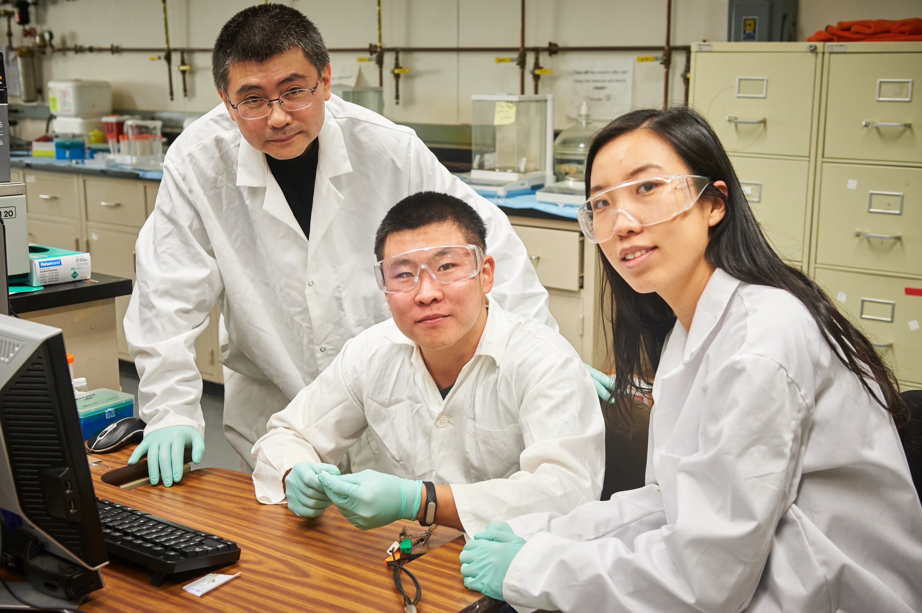 Yu Lei, Centennial Professor of chemical & biomolecular engineering, left, and graduate students in the lab. (Peter Morenus/UConn Photo)