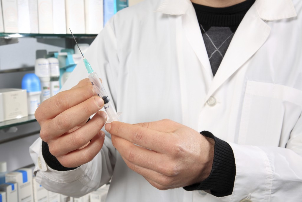 A pharmacist holding a syringe. (iStock Photo)