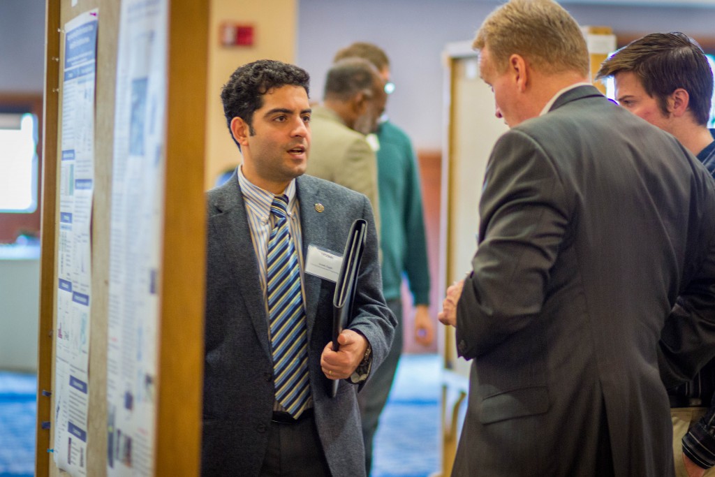 Arash Zaghi, assistant professor of civil and environmental engineering, left, speaks with industry partners during the School of Engineering's Open House in November 2015. (Chris LaRosa/UConn Photo)