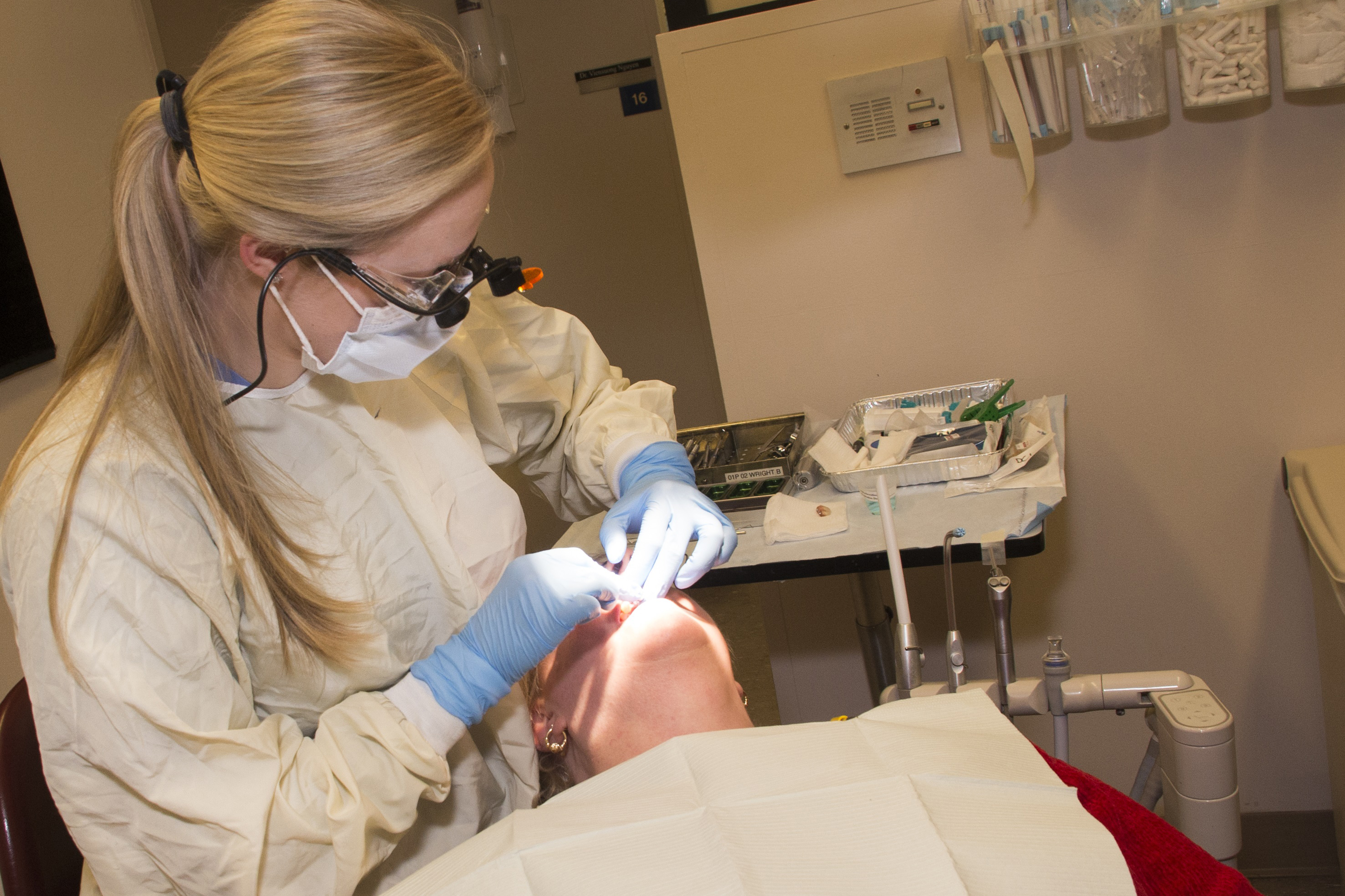 Dental resident Roberta Wright tends to a patient. (Janine Gelineau/UConn Health Photo)