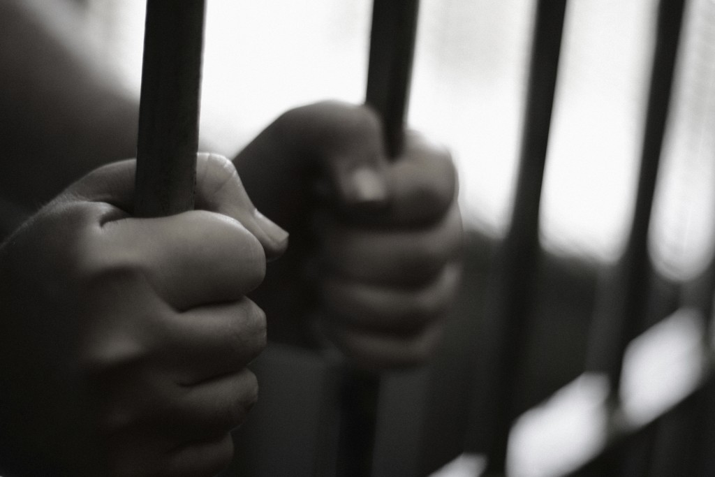 Hands grasping prison bars. (iStock Photo)