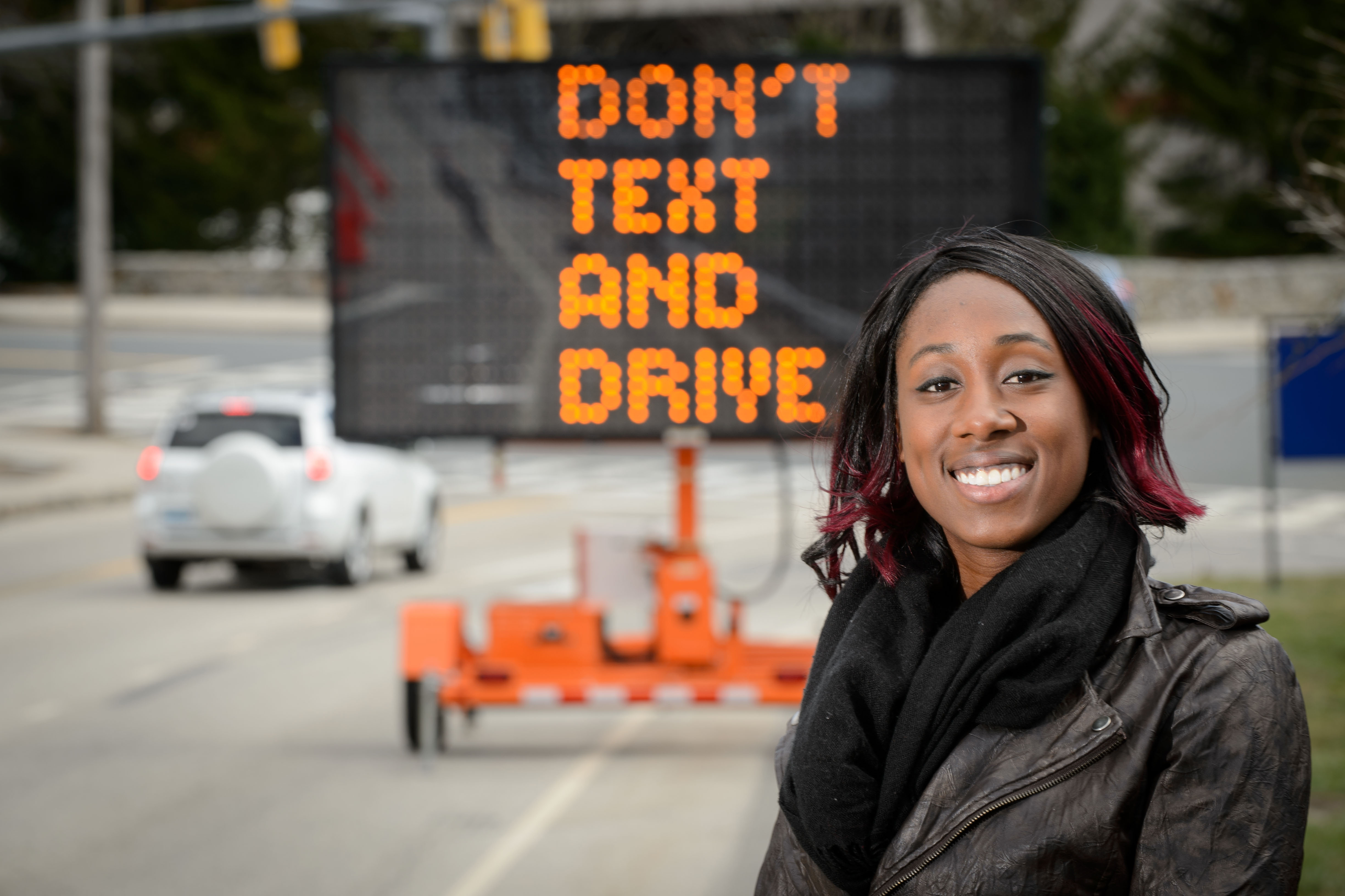 Marisa Auguste with a traffic safety sign on April 8, 2016. (Peter Morenus/UConn Photo)