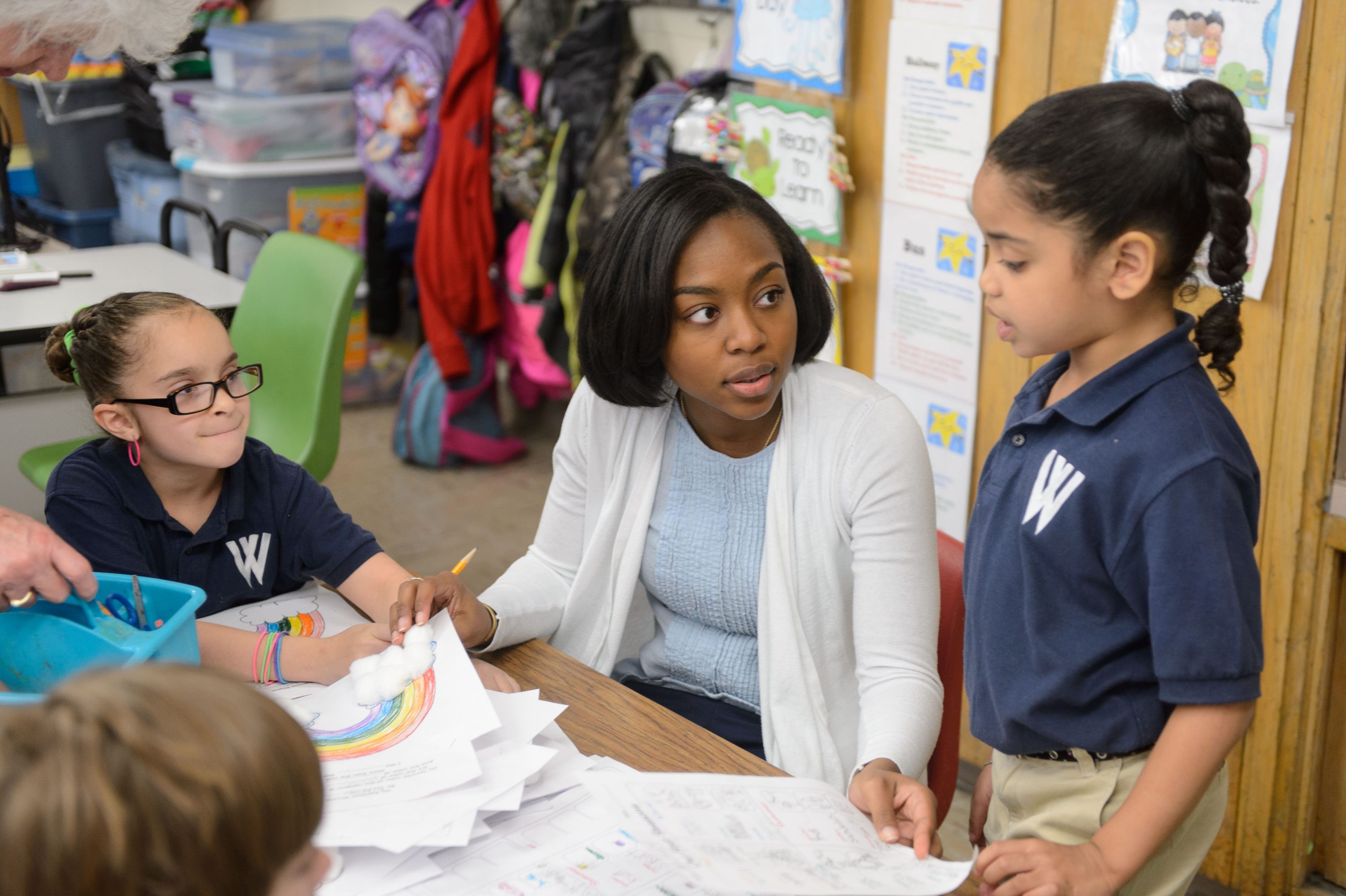 Symone James '16 (ED), a student teacher at W.B. Sweeney School in WIllimantic helps students with reading on April 26, 2016. (Peter Morenus/UConn Photo)
