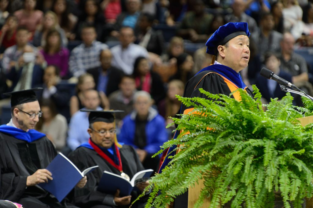 Provost Mun Choi speaks during the midday College of Liberal Arts and Sciences commencement ceremony at Gampel Pavilion on May 8, 2016. Seated at left are Associate Deans Andrew Moiseff and Dipak Dey. (Peter Morenus/UConn Photo)