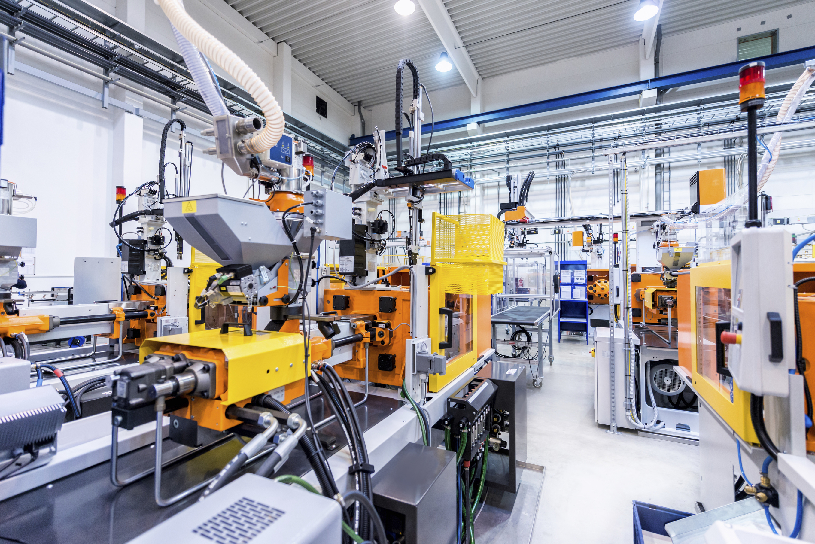 Horizontal color image of large group of automated injection moulding machines for plastic parts production. (iStock Photo)
