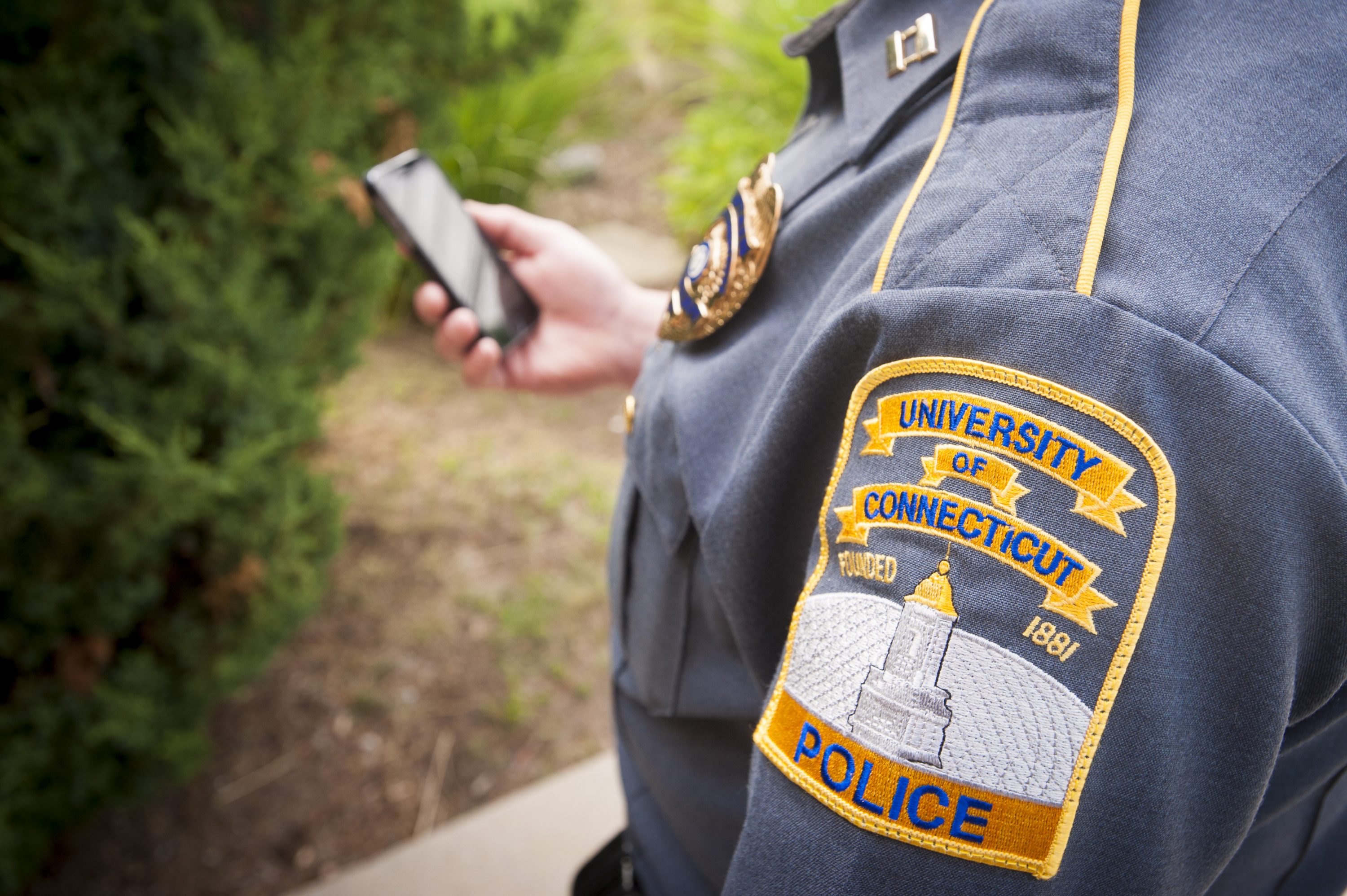 UConn Police Officer holding a cell phone on June 16, 2016. (Sean Flynn/UConn Photo)