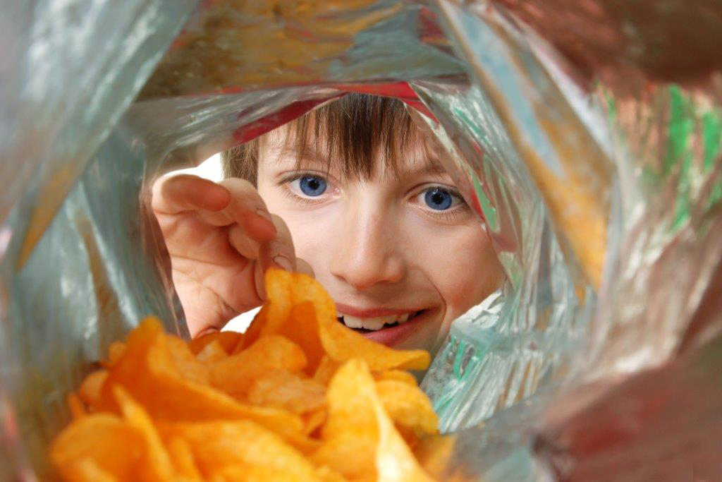 Child looking at chips in a bag. (iStock Photo)