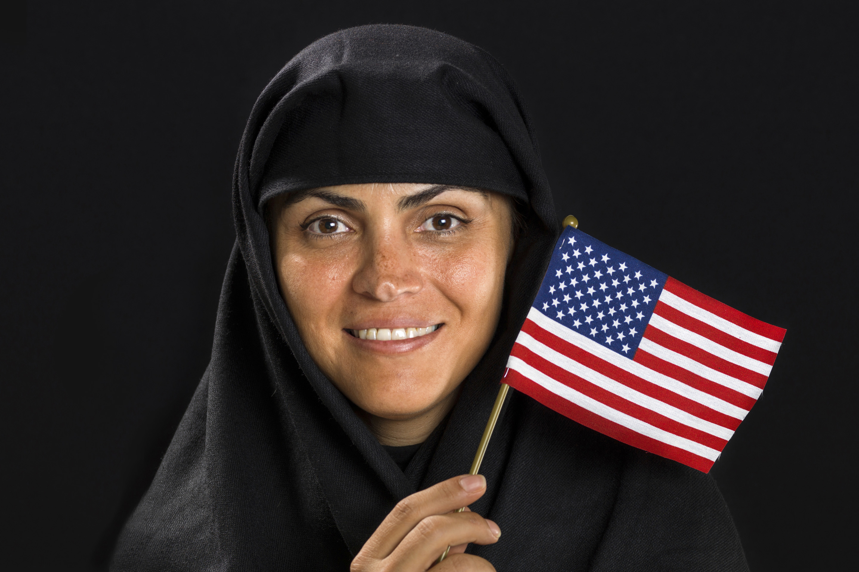 Muslim woman waving an American flag. (iStock Photo)