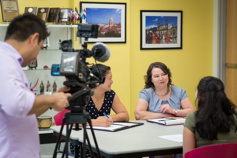 Juan Carlos Sanchez of Univision , left, records Jen Morenus '97 (SFA), assistant director, Fany D. Hannon '08 MA, director, and Natalia Gutierrez '18 (ENG) at the Puerto Rican/Latin American Cultural Center on Aug. 12, 2016. (Peter Morenus/UConn Photo)