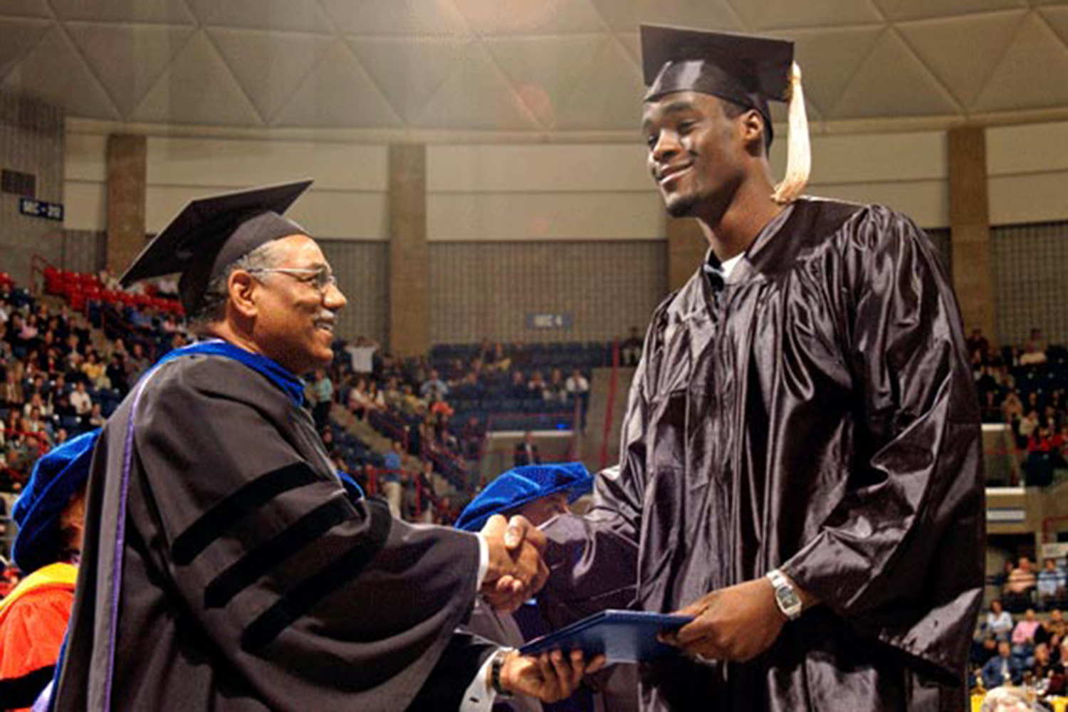 Emeka Okafor receives his diploma from former School of Business Dean Curt Hunter during Commencement ceremonies at Gampel Pavilion in May 2004. ( Ryan McKee/NCAA Photos)