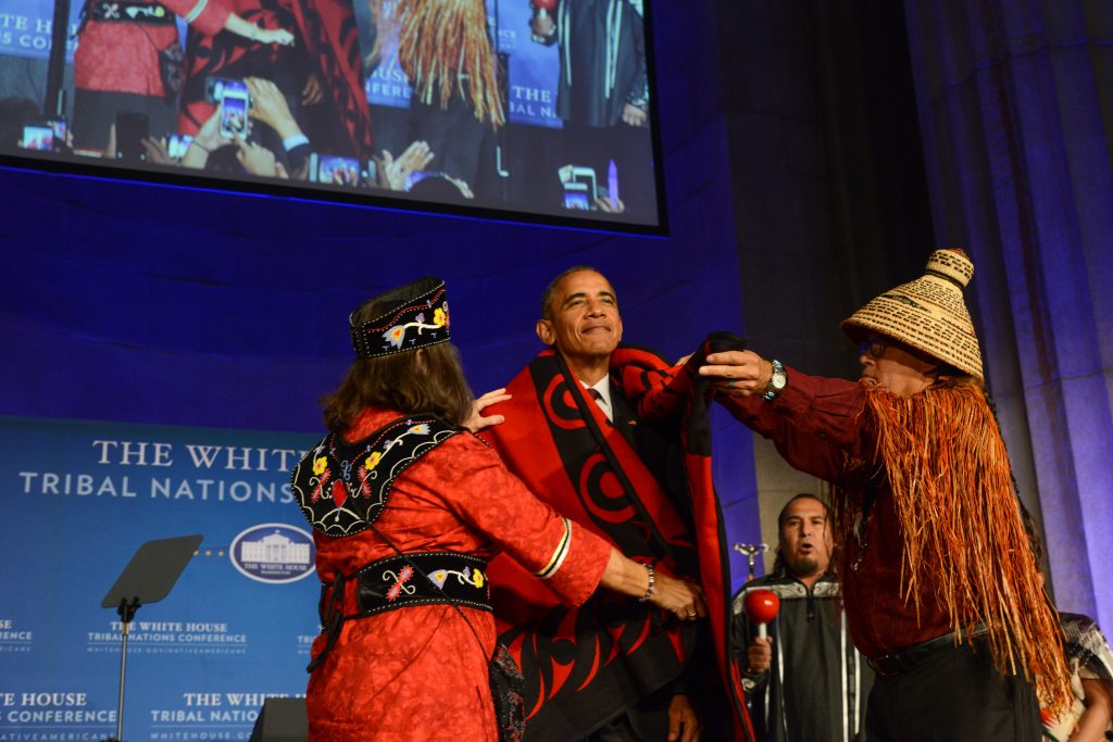 President Obama is presented with a blanket by Mohegan Chief Lynn Malerba, left, and Brian Cladoosby, right, president of the National Congress of American Indians, during the eighth annual White House Tribal Nations Conference. (U.S. Department of the Interior Photo)