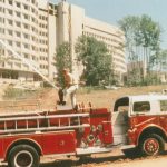 firefighter testing hose on fire engine