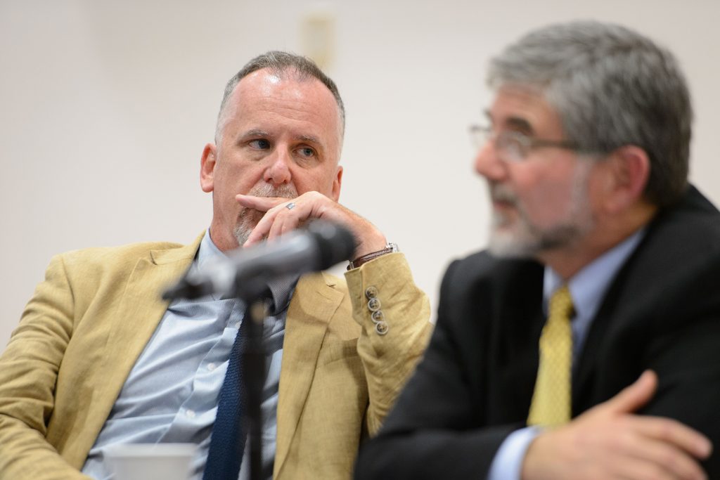 Michael Patrick Lynch, professor of philosophy and director of the UConn Humanities Institute, left, listens while Paul Herrnson, professor of political science, answers a question during a panel discussion on the presidential election at an event held at the Hartford Public Library on Sept. 22, 2016. (Peter Morenus/UConn Photo)