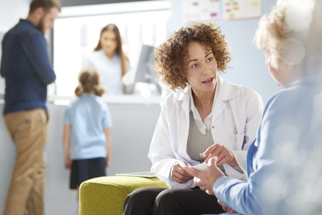A pharmacist sits with a patient in the consultation area and discusses her prescription. (iStock Photo)
