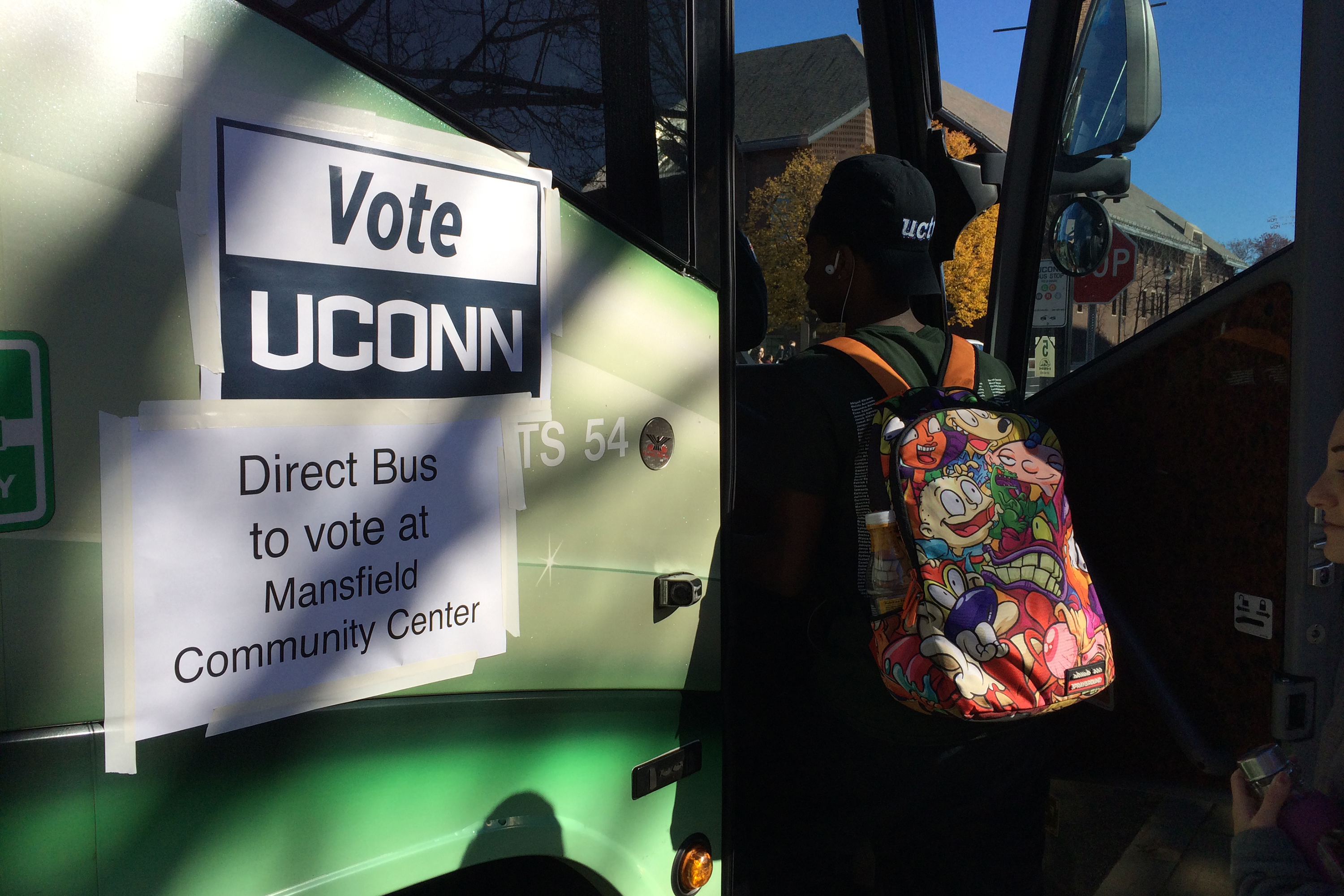 A student boards a bus headed to the polling station at the Mansfield Community Center on Nov. 8, 2016. (Peter Morenus/UConn Photo)