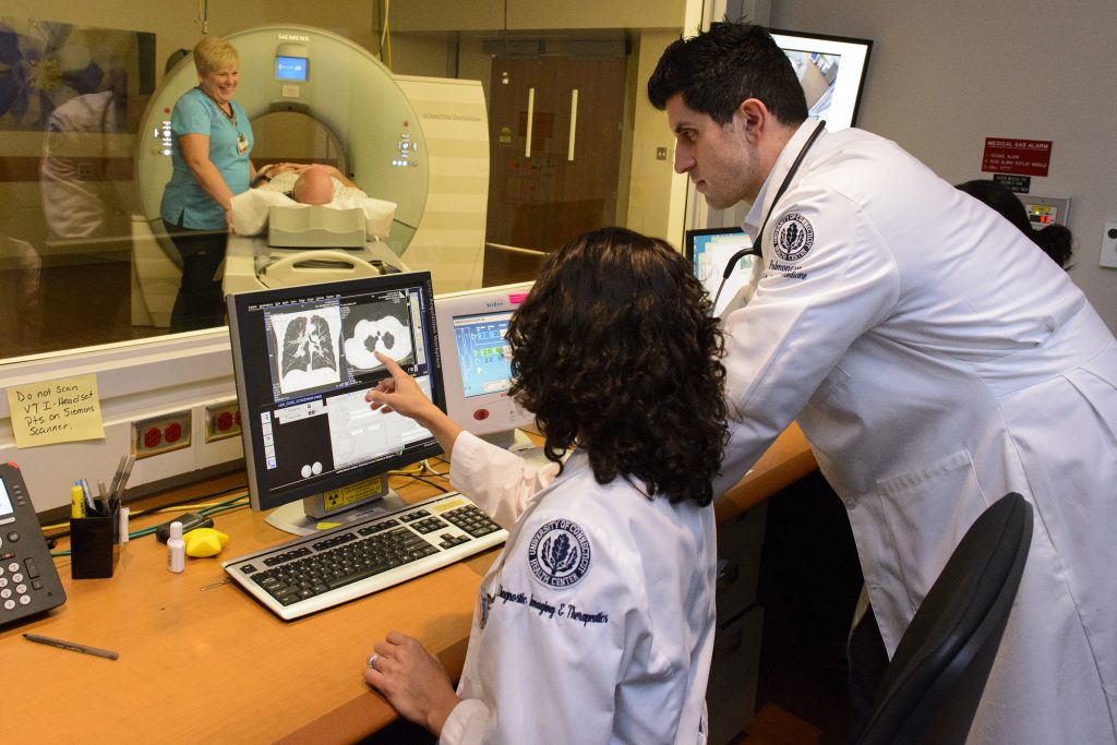 Dr. Omar Ibrahim, right, director of thoracic oncology at the Carole and Ray Neag Comprehensive Cancer Center, UConn Health, and Dr. Electra Kaloudis, section head of thoracic imaging in the Department of Diagnostic Imaging and Therapeutics, look over a low dose CT scan. (Janine Gelineau/UConn Health Photo)