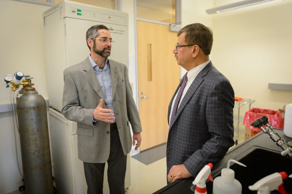 Anthony T. Vella, professor and Boehringer Ingelheim chair in immunology, left, speaks with President and CEO, Bijan Almassian at CaroGen Corp.'s technology incubation lab in Farmington on Dec. 12, 2016. (Peter Morenus/UConn Photo)