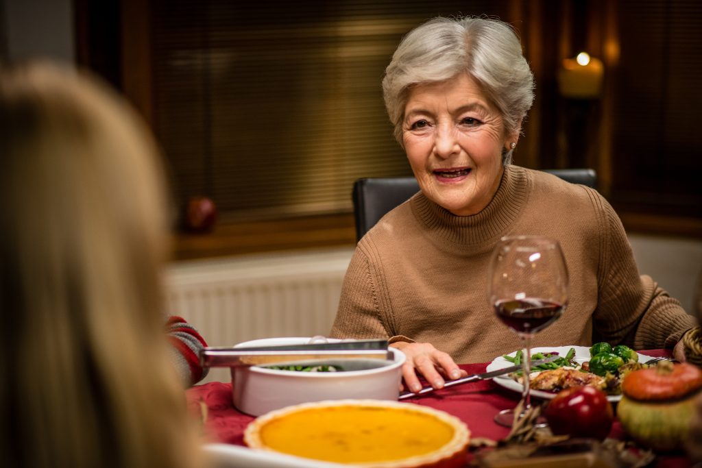 Senior woman in conversation at Christmas dinner. (vm/Getty Images)