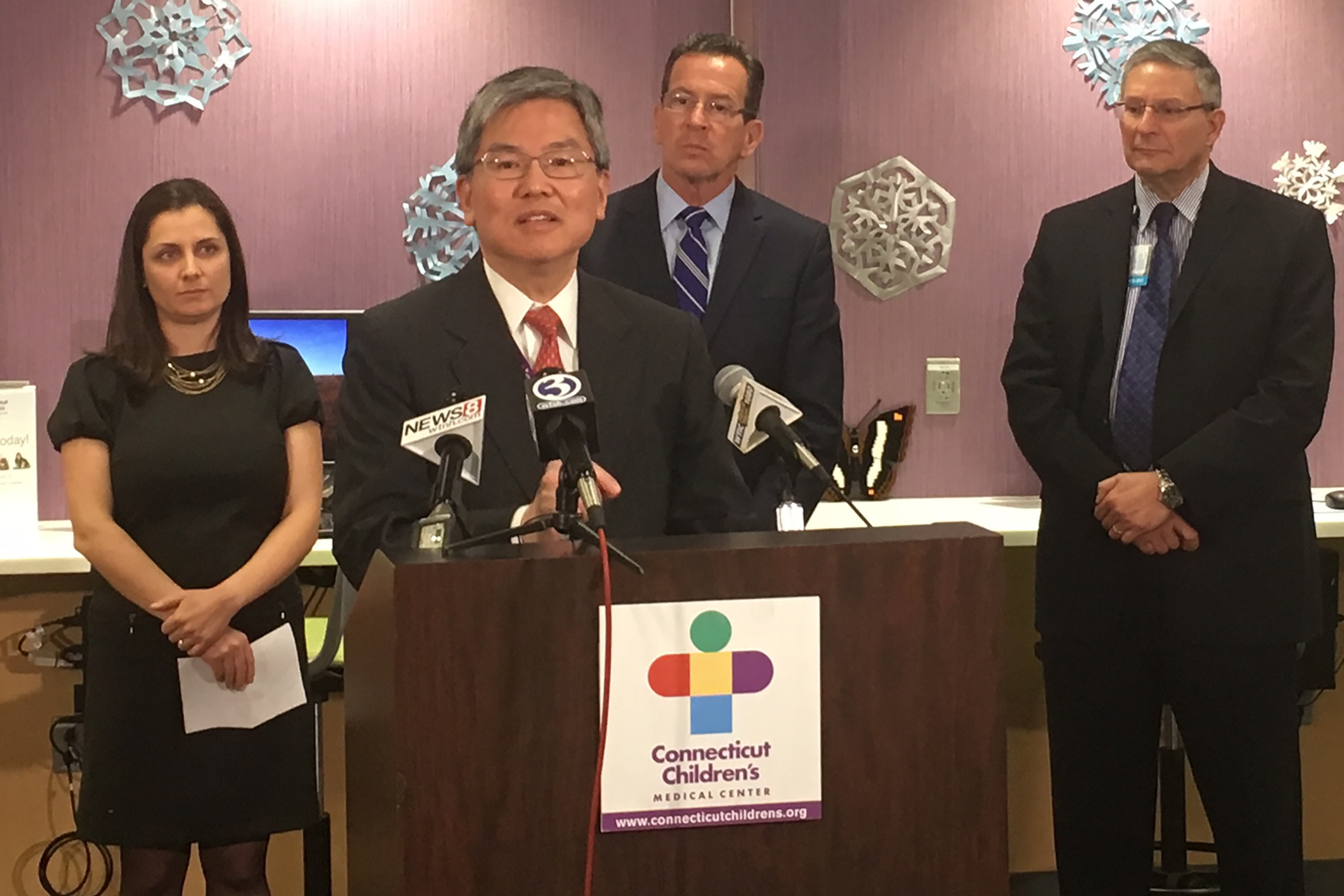 Dr. Ching Lau speaks at a press event to announce the 'Smash Childhood Cancer' global crowdsourcing research initiative. From left, Juan Hindo of IBM, Gov. Dannel P. Malloy, and Dr. Jim Shmerling, CEO of the Connecticut Children's Medical Center. (Lauren Woods/UConn Health Photo)