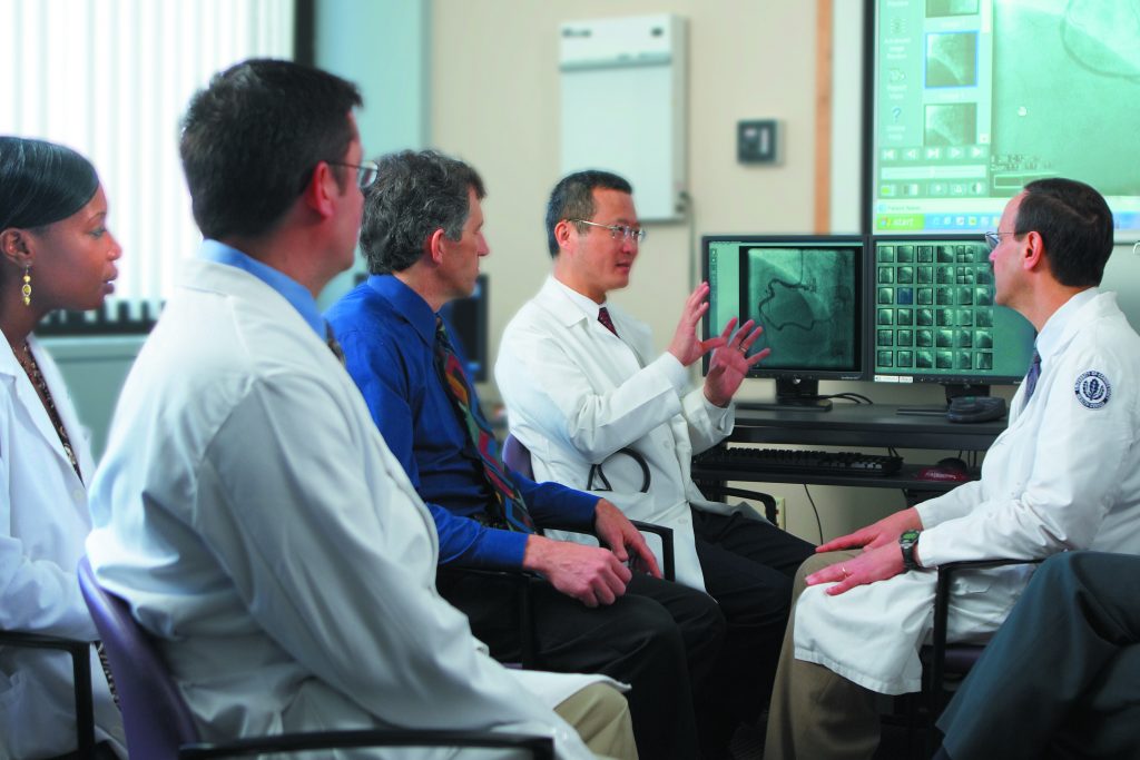Dr. Bruce Liang, center, reviews a patient's case with physicians from the Pat and Jim Calhoun Cardiology Center. (Lanny Nagler for UConn Health Center)