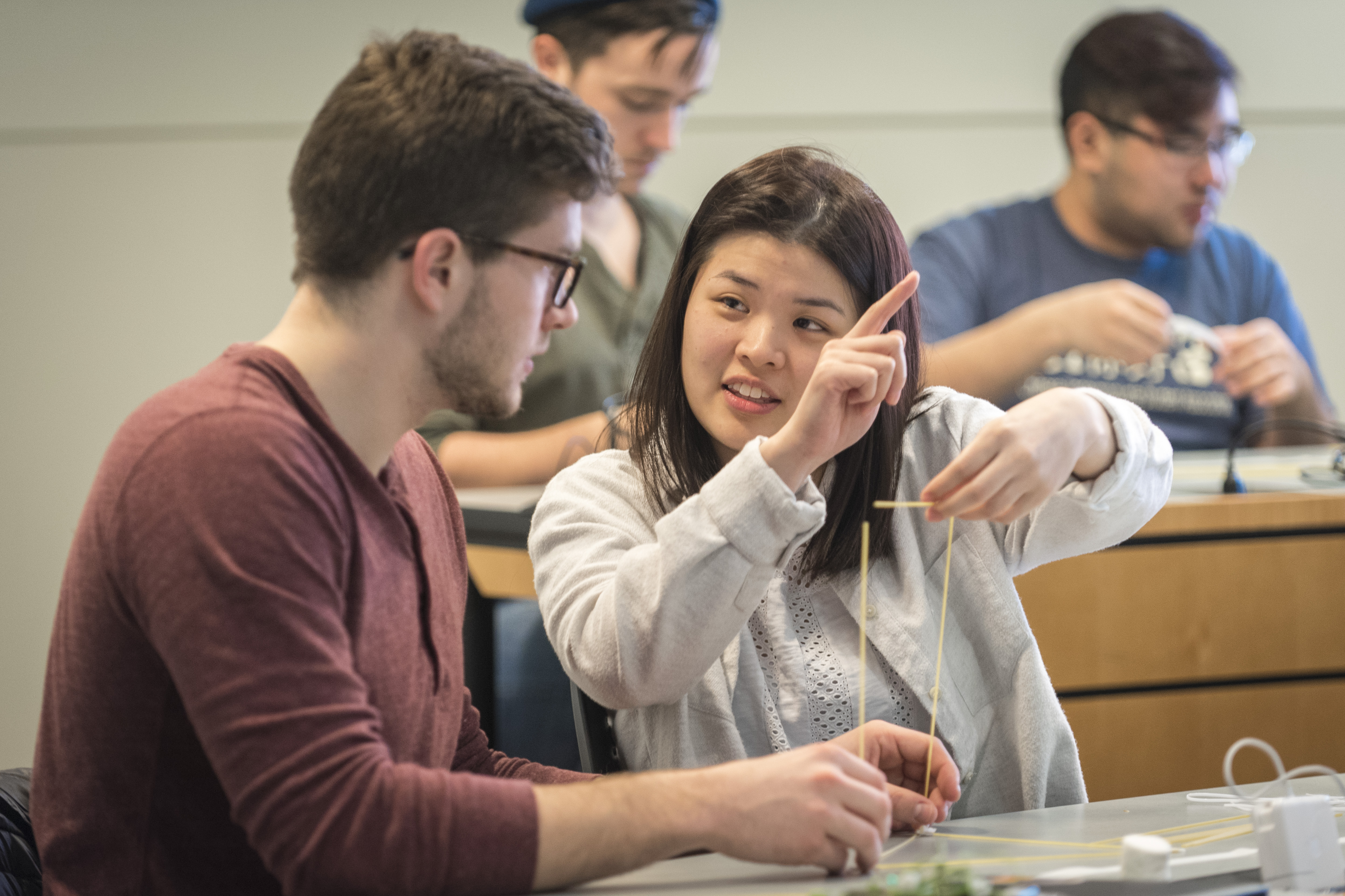 Undergraduates Richard Vincent III, left, and Cindy Lin discuss a hands-on exercise called 'Design Thinking: Marshmallow Challenge' during a class on incorporating game design into business planning. (Sean Flynn/UConn Photo)