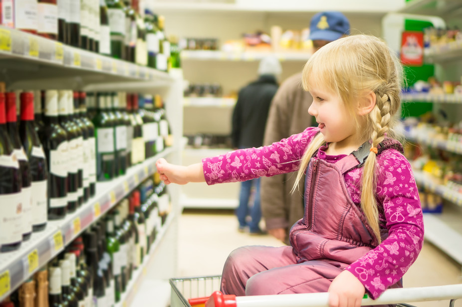 The alcohol industry still makes ads appealing to youth. Girl in shopping cart image via www.shutterstock.com.