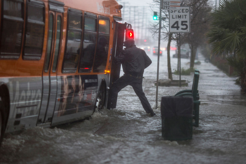 A man boards a bus on a flooded street as a powerful storm moves across Southern California on Feb. 17, 2017 near Sun Valley, Calif. After years of severe drought, heavy winter rains came to the state, and with them, the issuance of flash flood watches in three counties, and the evacuation of hundreds of residents from Duarte, Calif. for fear of flash flooding from areas denuded by a wildfire last year. (Photo by David McNew/Getty Images)