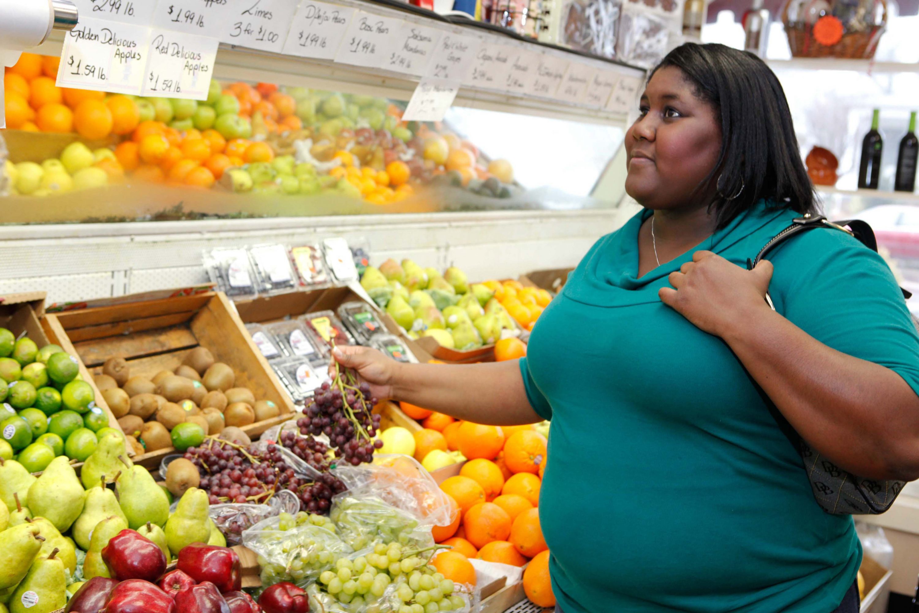 An overweight woman buying fruit at a grocery store. (UConn Rudd Center Photo)