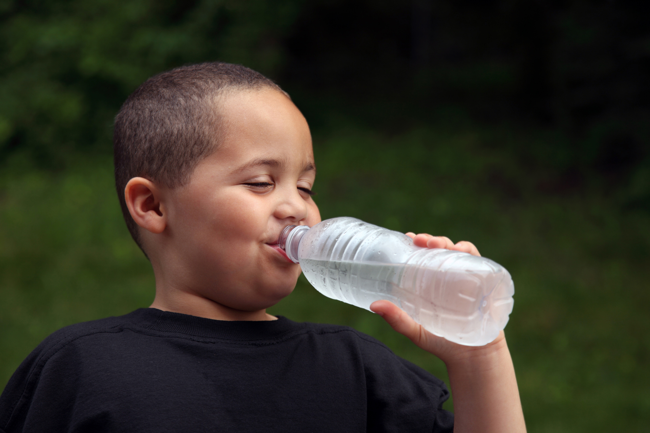 Latino boy drinking water from bottle. (Thinkstock Photo)