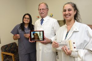 portrait of three people holding elements of a telemedicine program