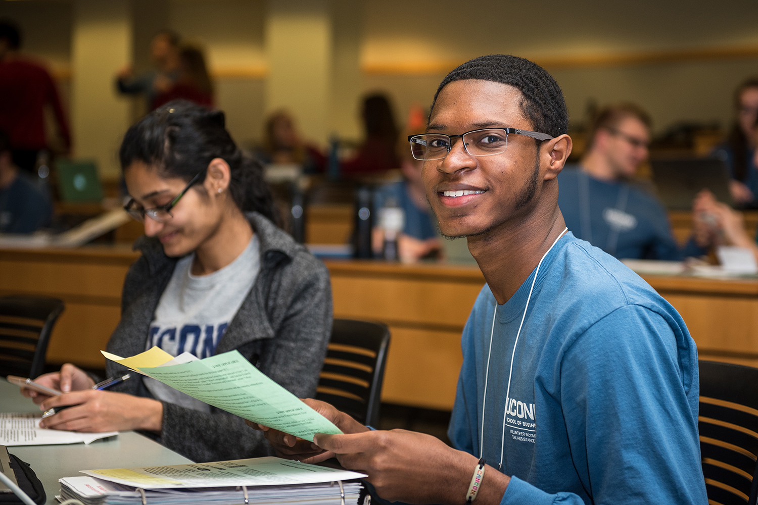 Sameir Rankins '17, right, helps a client with her tax return. (Devin Basdekian/UConn photo)