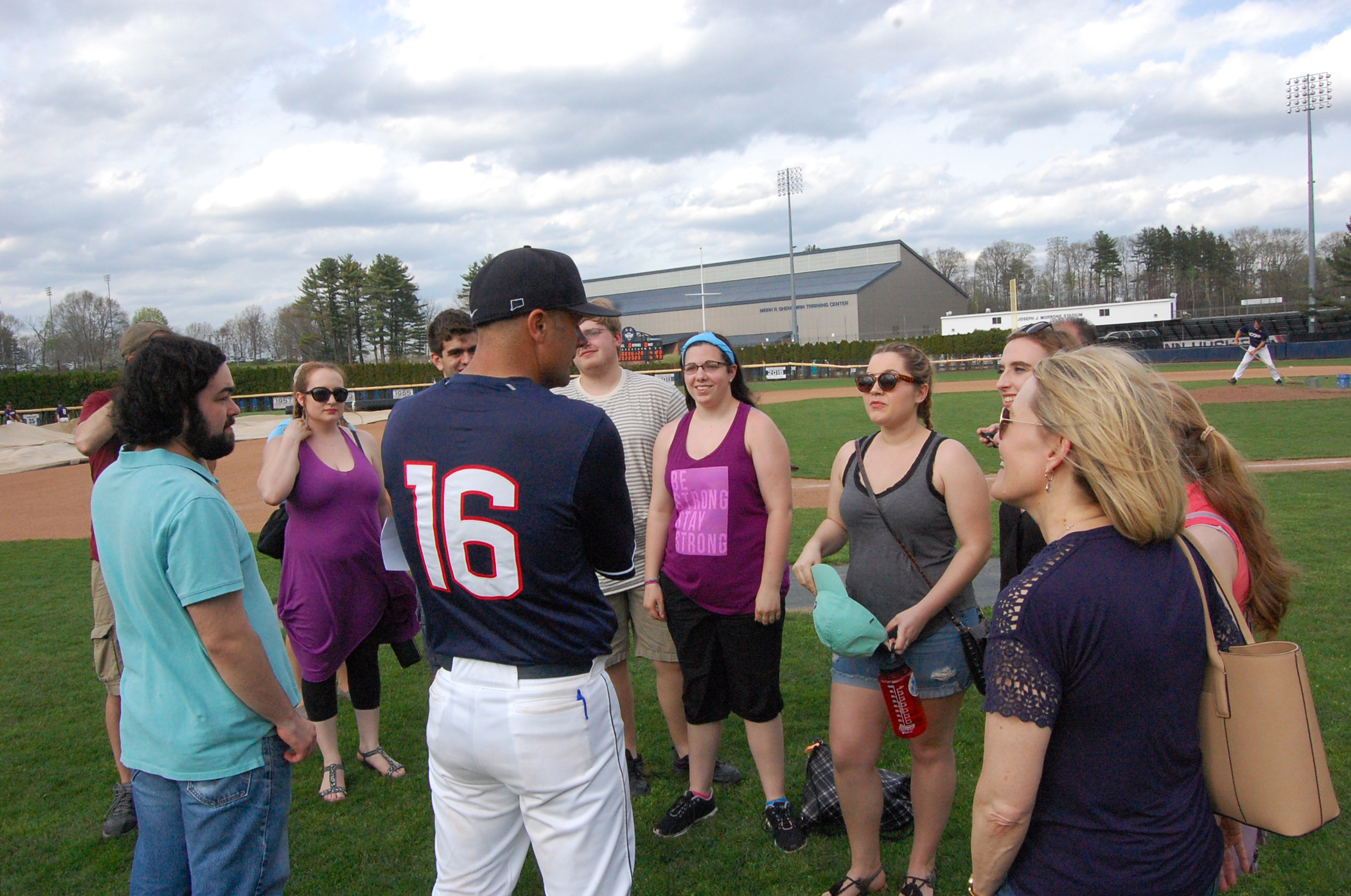 Head baseball coach Jim Penders ’94 (CLAS), ’98 MA, speaks with undergraduate and graduate music students who performed in “H.M.S. Pinafore” following the Huskies’ win over Cincinnati on April 30. (Kenneth Best/UConn Photo)