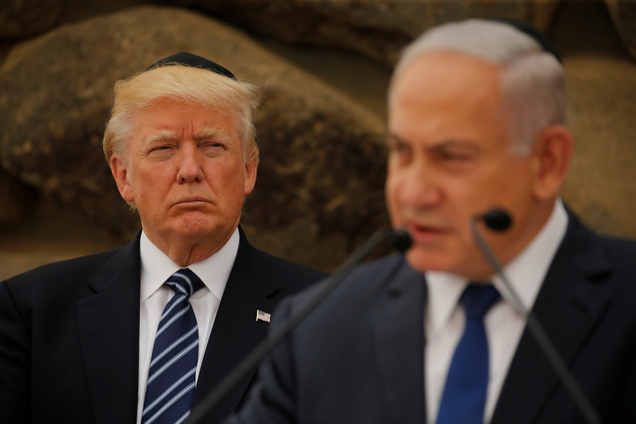 President Donald Trump listens as Israeli Prime Minister Benjamin Netanyahu speaks at a podium during Trump's recent Middle East visit. (REUTERS/Jonathan Ernst, via The Conversation)