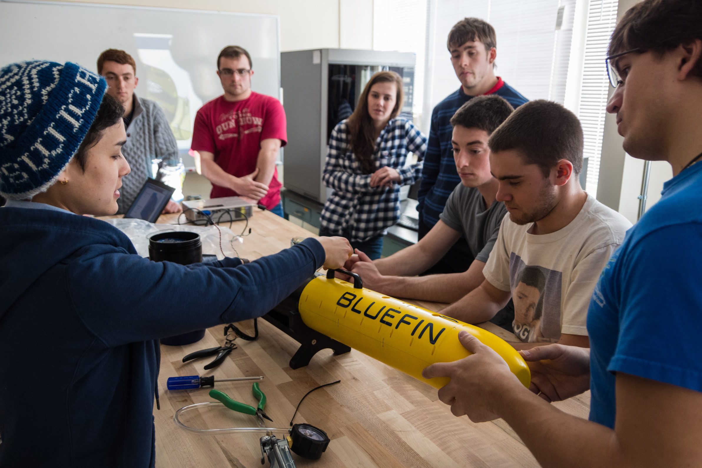 The Navy STEM Crew incorporates community building, education, leadership, and professional development components to inspire students and prepare them for Navy careers. Here, URI students from the Department of Ocean Engineering are conducting prep for an at-sea test of an autonomous underwater vehicle. (University of Rhode Island Photo)