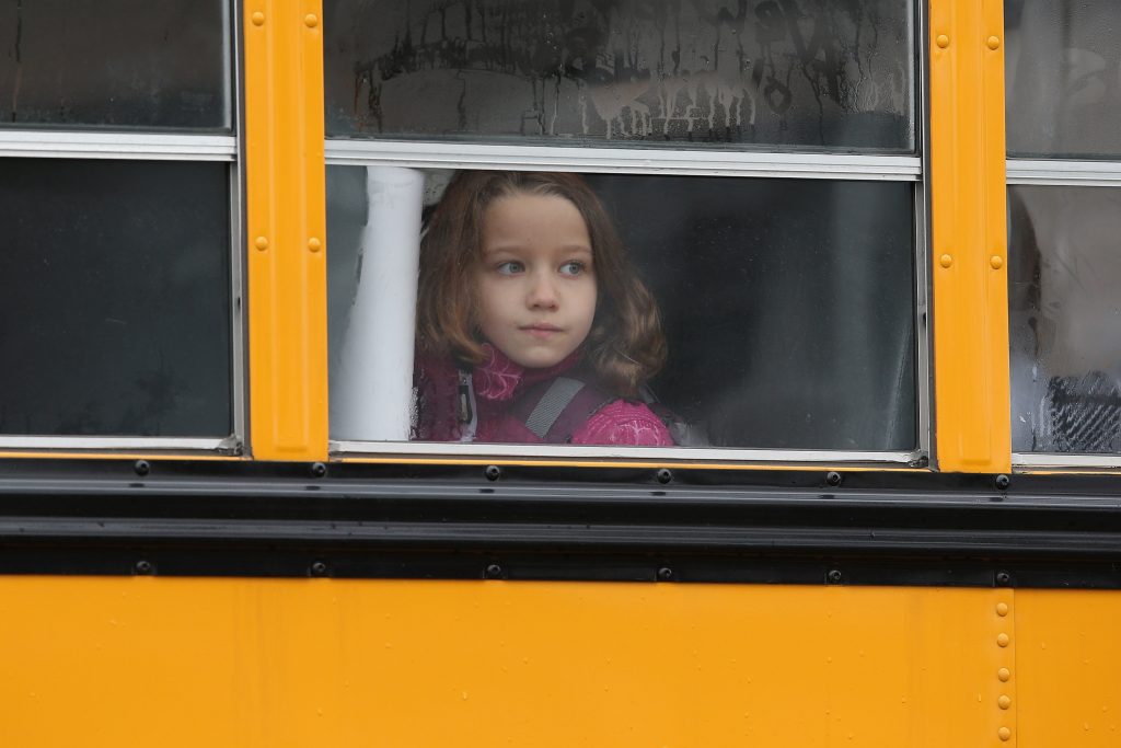 A child gazes from a school bus. (Photo by John Moore/Getty Images)