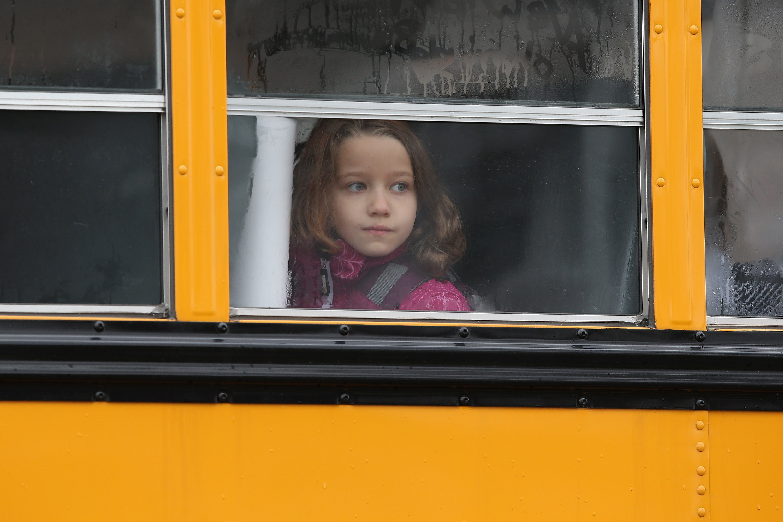 A child gazes from a school bus. (Photo by John Moore/Getty Images)
